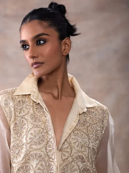 A profile shot that highlights the elegant neckline of the garment and the clean makeup. The focus is on sculpted cheekbones and a perfectly blended smokey eye.