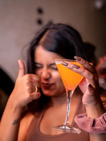A guest giving a thumbs up to her cocktail. The drinks are just as important as the music for the perfect vibe.