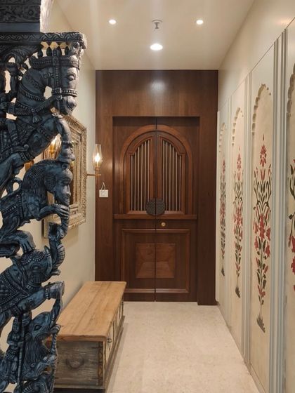 A wider view showing how the painted panels integrate into the hallway, leading the eye towards the intricately carved door and creating a cohesive, traditional aesthetic.