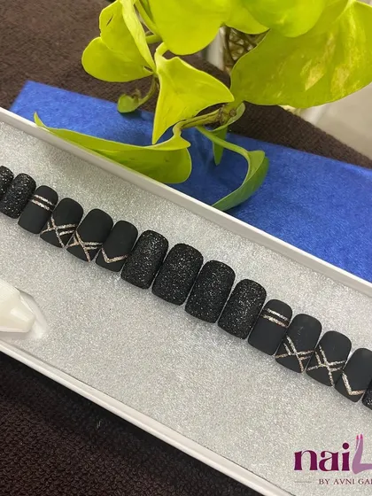 For the love of black. This set of press-on nails features a mix of matte black, textured glitter, and silver chrome lines for a bold, edgy look.