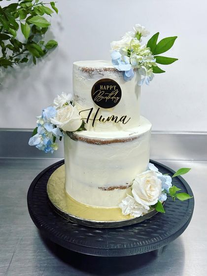 A pretty cake for a pretty human. This two-tiered semi-naked cake is filled with our signature three-berry compote and lemon curd, and decorated with fresh flowers for a beautiful birthday celebration.