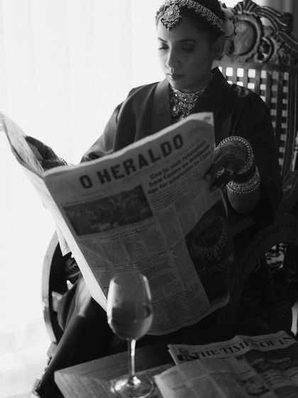 A creative and editorial-style bridal portrait. The bride reading a newspaper in her getting-ready attire is a unique, story-driven concept that I love to explore.