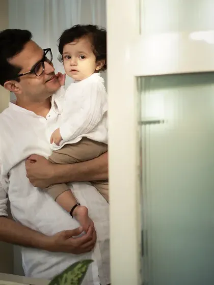 A quiet, intimate moment between a father and his son, framed by the window. This is the kind of gentle, heartfelt connection I strive to capture.