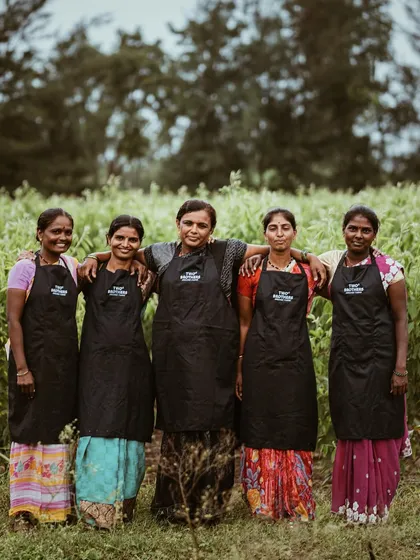 A proud team of women from TBOF posing in a field. This photo celebrates the people behind the brand, adding a powerful layer of authenticity and community to their story.
