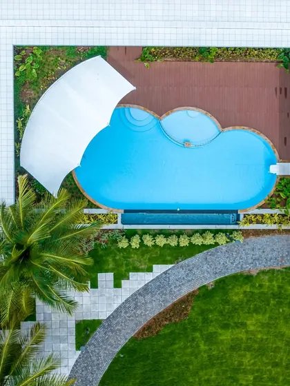 Our designs extend to creating complete lifestyle experiences. This aerial view captures the leisure-focused heart of a farmhouse project, where the swimming pool is thoughtfully integrated within a courtyard, offering privacy and a resort-like feel.