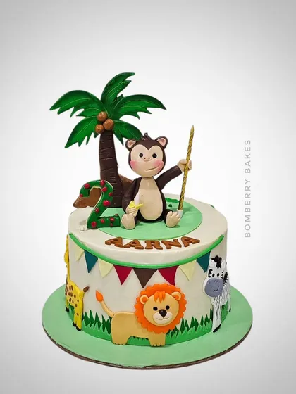 A different take on the safari theme, this cake for Aarna's 2nd birthday features 2D fondant animals and a playful monkey topper.