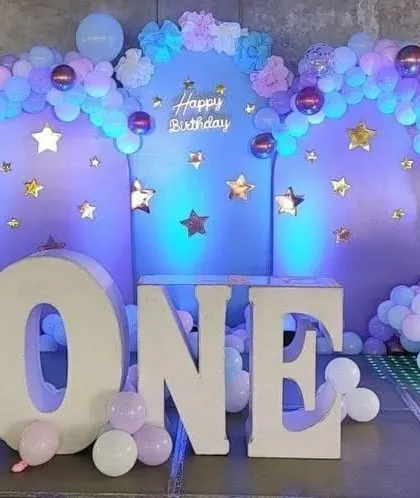 A dreamy 'Twinkle Twinkle Little Star' theme with a purple and blue color palette. Large 'ONE' letters and star cutouts complete the celestial look.