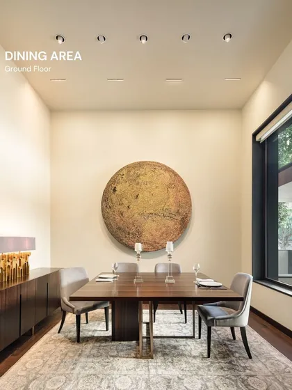 In this Vasant Vihar residence, the dining area is anchored by a monumental piece of art. The design is intentionally minimalist to allow the artwork to command the space, creating a gallery-like experience for everyday dining.
