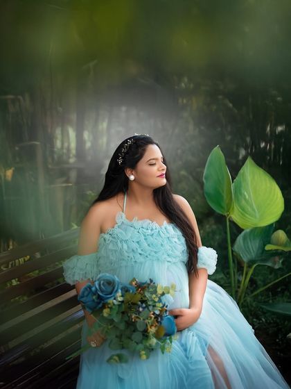 A close up shot of the mom to be, seated on a bench in a lush garden. The soft focus and rich green tones make this a beautiful, intimate portrait.