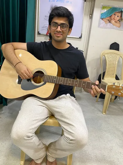Many adults join our academy to pick up a new hobby or revisit an old one. This student is focused on his acoustic guitar lesson, learning chords and songs in a relaxed setting.