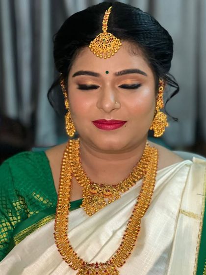 For this Muhurtham, we chose a beautiful white and green saree. The makeup features soft golden eyes and a classic red lip to create a look of timeless elegance.