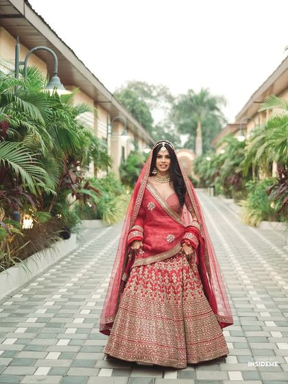 The full bridal portrait. Kanika looks stunning in her red lehenga, with her classic makeup and hair completing the timeless look.