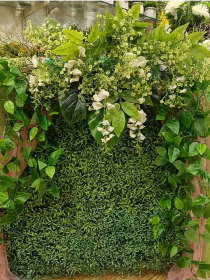 For a lush, jungle-inspired look, this ready-made backdrop uses a variety of green foliage to create a dense and natural-looking wall.
