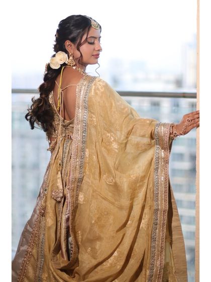 This shot from the back reveals the elegant low-back blouse and the way the dupatta is draped, along with the intricate details of her hairstyle.