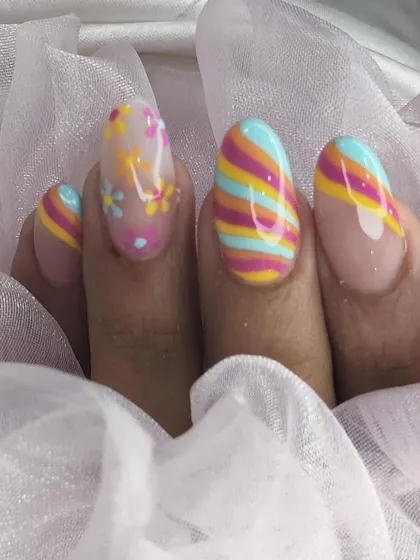 A close-up of the colorful pastel striped and floral nail art.