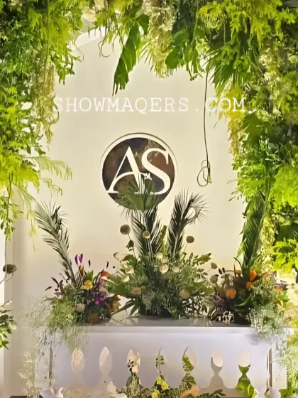 A custom monogrammed photo point framed by an arch of tropical greenery, creating a personalized and stylish backdrop.