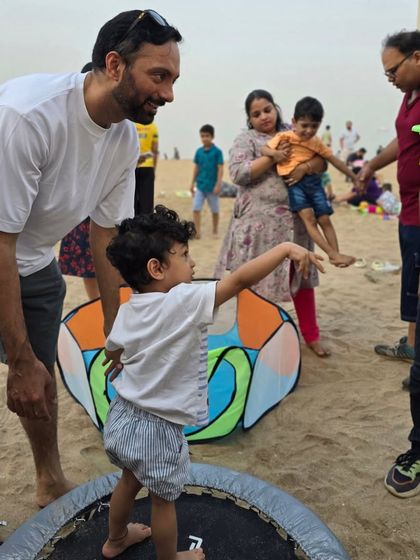 A father and son enjoy the trampoline basketball game together. These shared moments of fun and activity are what make our beach playdates so special.
