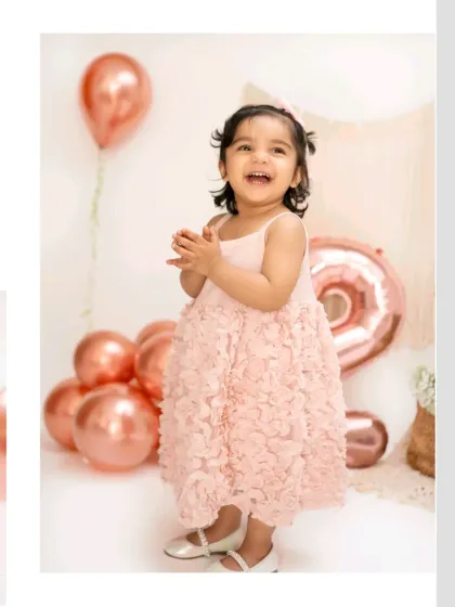 A candid shot of a laughing two-year-old, surrounded by rose gold balloons. These spontaneous moments of joy are what we love to capture.