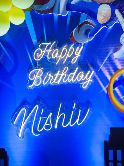 A custom "Happy Birthday Nishiv" neon sign adds a modern and personalized touch to the Sonic party decor.
