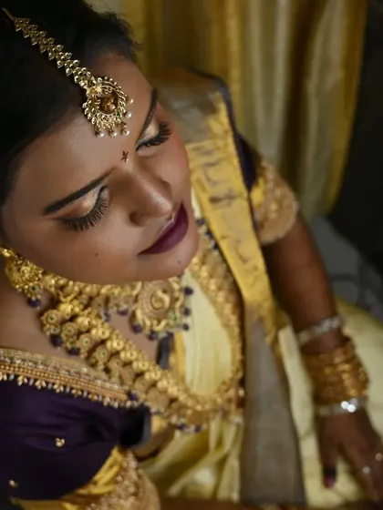 An artistic top-angle shot. This view highlights the bride's maang tikka, her intricate jewellery, and the rich color of her silk saree.