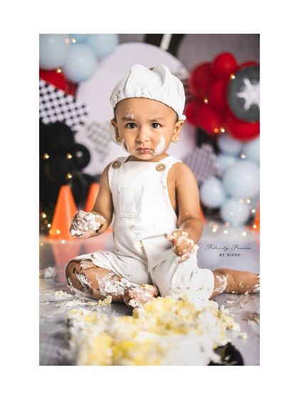 A close-up of the messy hands and face of a baby boy after his first cake smash. These are the details to treasure.