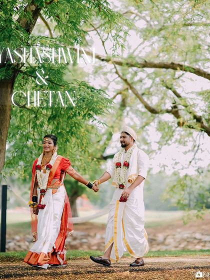 Yashashwini and Chetan walking hand-in-hand through the lush greenery of Kimmane Resorts, a perfect destination wedding shot.