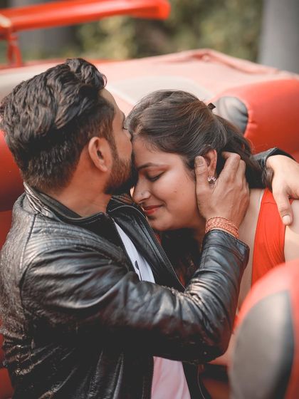 A tender close-up of the groom kissing the bride's forehead in a classic car, a perfect intimate moment for a pre-wedding album.