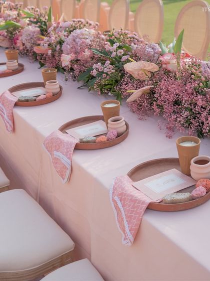 A low-seating arrangement for a traditional ceremony, with custom-printed napkins and favors placed on wooden trays for each guest.
