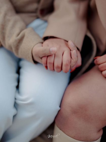 A close-up on their intertwined hands, a simple yet powerful symbol of their connection and the promise of their future together.