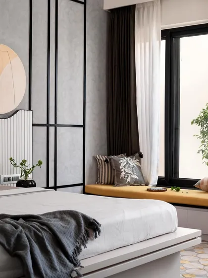 This angle shows the full layout of the master bedroom, including the cozy bay window seating with a pop of yellow, which contrasts beautifully with the monochrome and wood tones of the room.