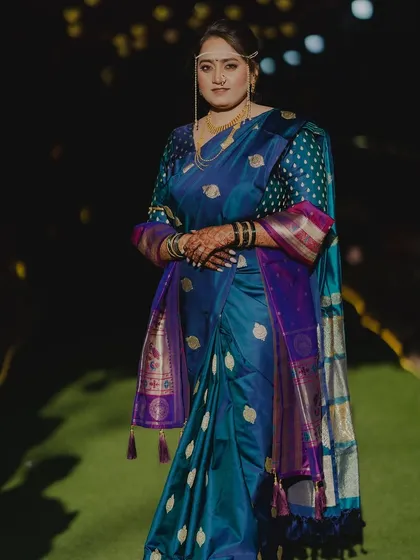 Draped in a traditional blue Nauvari saree, this bride glows with grace under the evening lights.