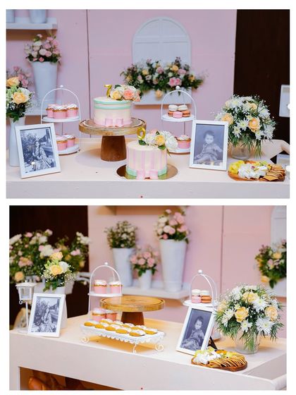 The beautifully arranged dessert table, featuring cakes and pastries on elegant stands. Framed photos and floral arrangements add a personal and sophisticated touch to the display.