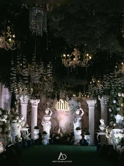 A romantic and dramatic entranceway designed to feel like a secret garden at night. The combination of lush greenery, classical statues, and dozens of sparkling chandeliers creates an immersive, magical experience for guests.