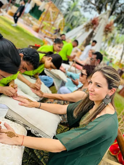 A happy guest getting her mehndi done at a beautiful outdoor event. My team ensures every guest receives a beautiful design and a wonderful experience.