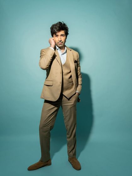 A full-length shot from the same session, showing the complete suit and a confident, relaxed pose.