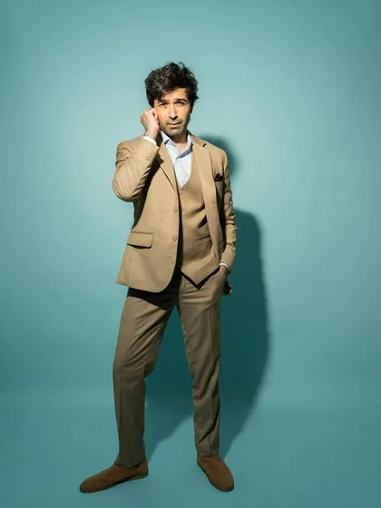 A full-length shot from the same session, showing the complete suit and a confident, relaxed pose.