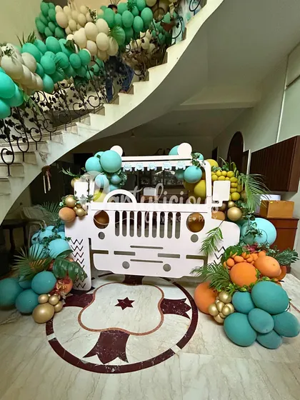 Our custom-built safari jeep prop is always a huge hit. Here, it's decorated with colorful balloons and placed at the bottom of a staircase, turning a simple home entrance into a photo-ready adventure zone.