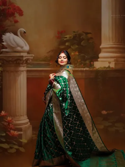 A portrait of the mother-to-be looking back gracefully. The elegant posture and the rich fabric of the saree are beautifully captured in this artistic shot.