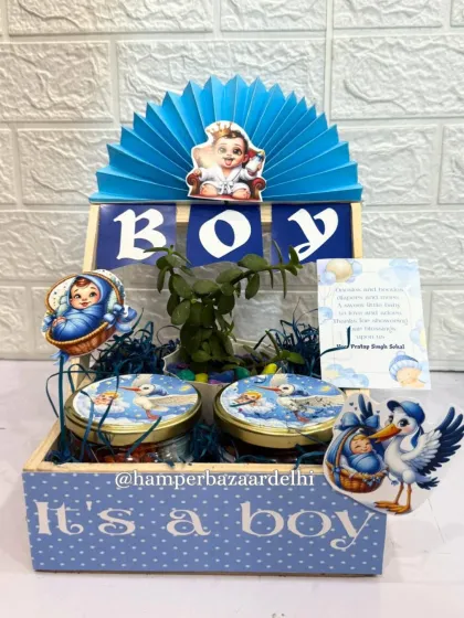 A classic 'It's a Boy' announcement hamper in a pinewood crate, filled with treats and a planter.