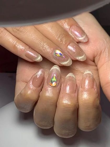 A close-up of the elegant cat-eye nails with a single crystal accent.