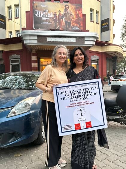 With a fellow activist holding a placard that reads "Your Vote Is Your Voice". We organized this drive outside a cinema hall to remind people that their vote is more important than any weekend entertainment.