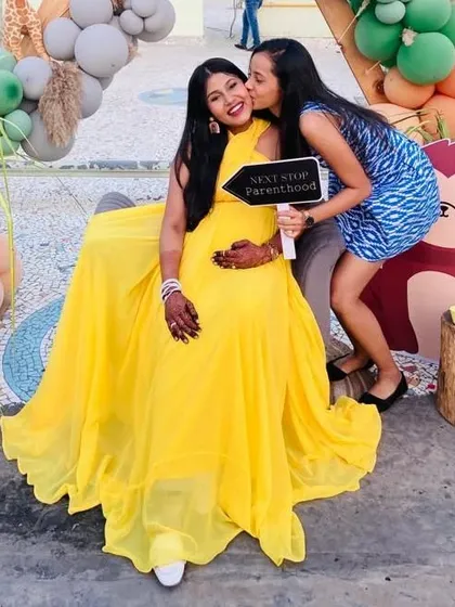 Celebrate your baby shower in style with a gown that is both comfortable and beautiful. This mom-to-be looks radiant in a bright yellow infinity gown, a perfect gender-neutral color for the happy occasion.
