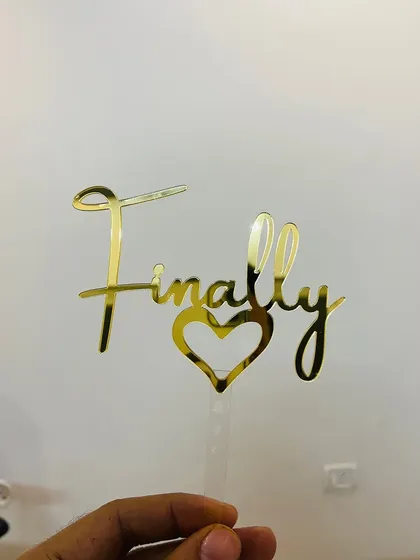 A clear, straight-on shot of the "Finally" topper, showcasing its elegant script and heart detail.