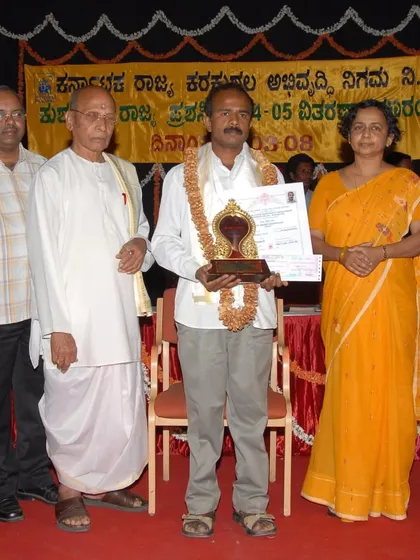 Artist Raghavendra B.B. being honored with the Karnataka State Award for Mysore paintings in 2003-2004.