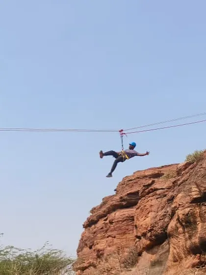 A participant enjoys the thrill of ziplining across a canyon during our Basic Rock Climbing Course at Badami.