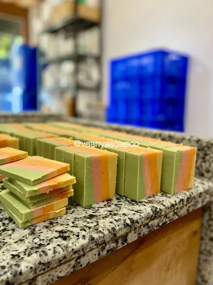 Our Tropical Escape soaps curing on the rack in our studio. The stacked bars show off their vibrant, summery colors. Nothing beats the smell of a fresh batch!