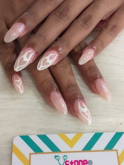A softer take on the flame trend, this set features white flame outlines on a shimmery, nude base. The design on these long oval nails is both cool and elegant.