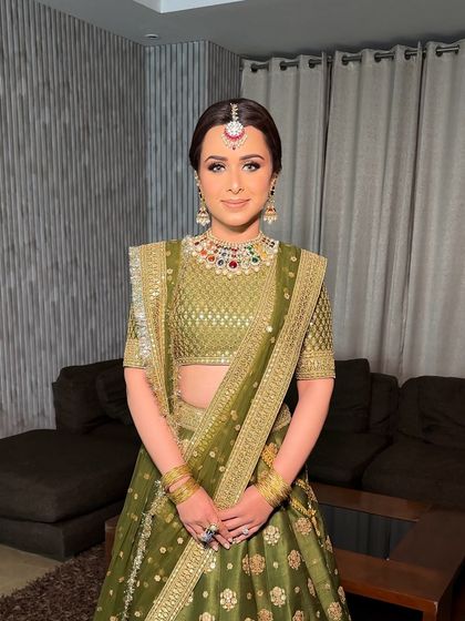 Another portrait of the bride, showcasing her complete traditional look with the ornate Sabyasachi lehenga and jewelry-adorned braid.