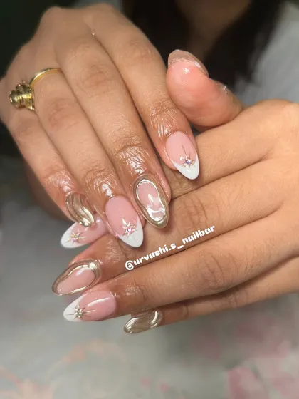 This festive design combines a classic white French tip with modern gold chrome swirls and tiny star-shaped rhinestone accents. It's a glamorous and sophisticated look.
