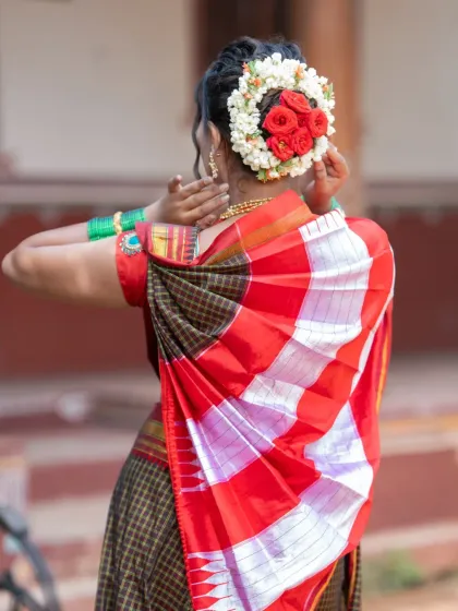 A beautiful view of a classic bridal bun, decorated with fresh jasmine and roses. This traditional hairstyle is elegant and timeless, and I make sure it's securely pinned to last all day.